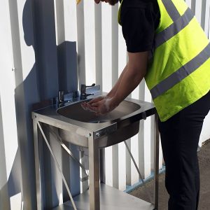 Stainless steel emergency basin unit with bottle trap and waste, designed for quick setup and hygiene on construction sites.